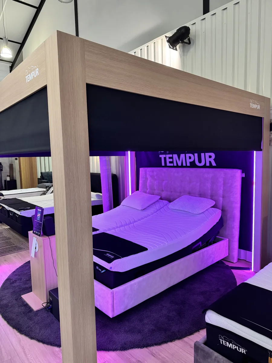 Le rideau de la cabine de démonstration TEMPUR® descend, éclairage d'ambiance allumé